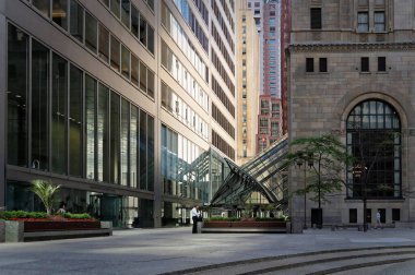 TORONTO, CANADA - 06 28 2016: Ticaret Mahkemesi Avlusu 'ndaki gökdelenler arasındaki geçitte beyaz gömlek ve siyah pantolon giyen bir ofis çalışanı