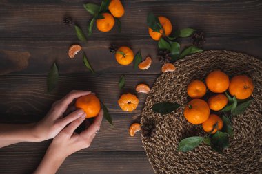 Mandalina ahşap arka plan üzerinde tutan eller. Smartphone için iyi duvar kağıtları