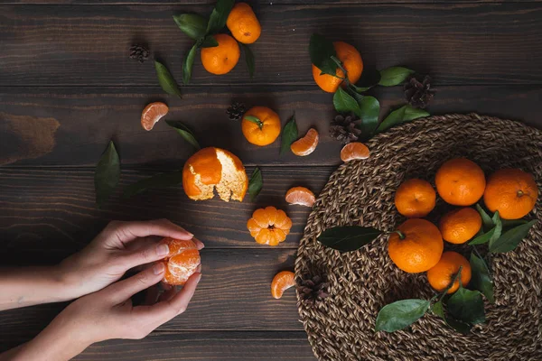 Female hands holding tangerine on wooden background. Good Wallpapers for smartphone