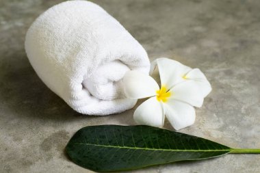 Spa havlu ile plumeria gri taş masanın üzerine.