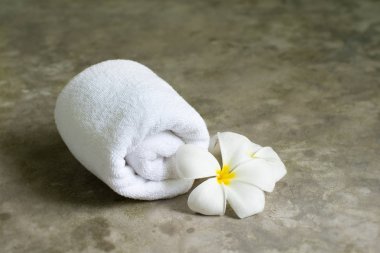 Spa havlu ile plumeria gri taş masanın üzerine.