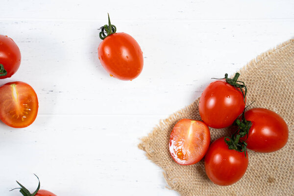 Fresh cherry tomatoes on a white wood background.