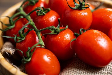 Koyu ahşap arka plan üzerinde bir tabakta taze kiraz domates.