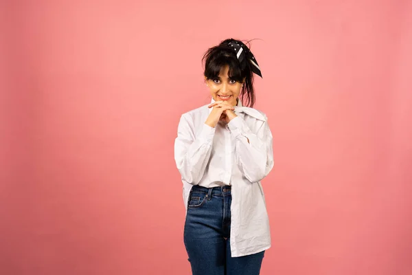 Joven hermosa chica en una camisa blanca posando para una foto sobre un fondo rosa . —  Fotos de Stock