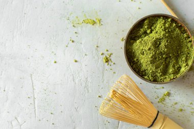 Gri bir arka plan üzerinde kahverengi bir fincan Matcha çay