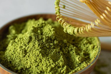 Gri bir arka plan üzerinde kahverengi bir fincan Matcha çay