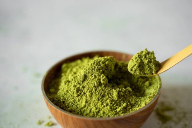 Gri bir arka plan üzerinde kahverengi bir fincan Matcha çay