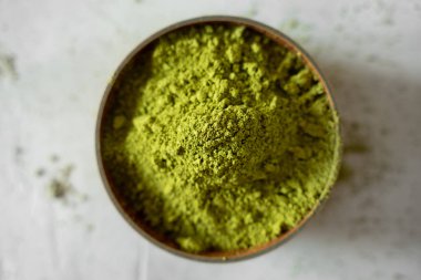 Gri bir arka plan üzerinde kahverengi bir fincan Matcha çay