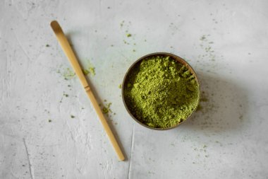 Gri bir arka plan üzerinde kahverengi bir fincan Matcha çay