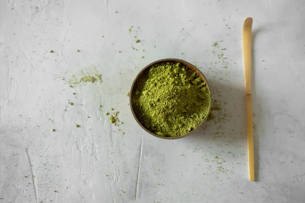 Gri bir arka plan üzerinde kahverengi bir fincan Matcha çay