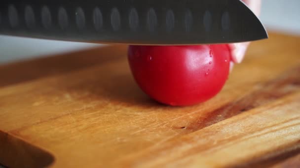 男性の手は鋭いナイフで木の板に新鮮なジューシーなトマトを切り — ストック動画