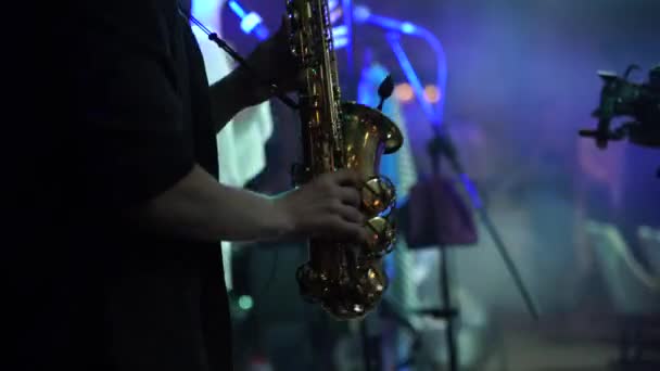 Un joven músico toca el saxofón en un concierto — Vídeo de stock
