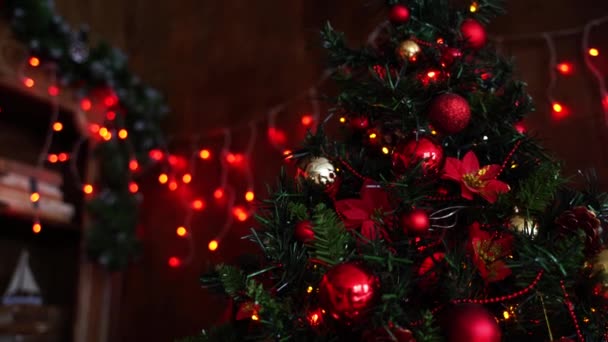 Velký vánoční stromek je zdoben krásnými červenými a oranžovými kuličkami.