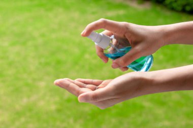 Taylandlı kadın ellerini alkol bazlı el yıkama spreyiyle siler. El hijyen Corona virüsü koruması için Coronavirus önleme. COVID-19 önleme içeride dezenfekte ediliyor.