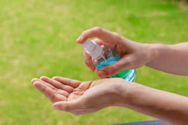 Taylandlı kadın ellerini alkol bazlı el yıkama spreyiyle siler. El hijyen Corona virüsü koruması için Coronavirus önleme. COVID-19 önleme içeride dezenfekte ediliyor.
