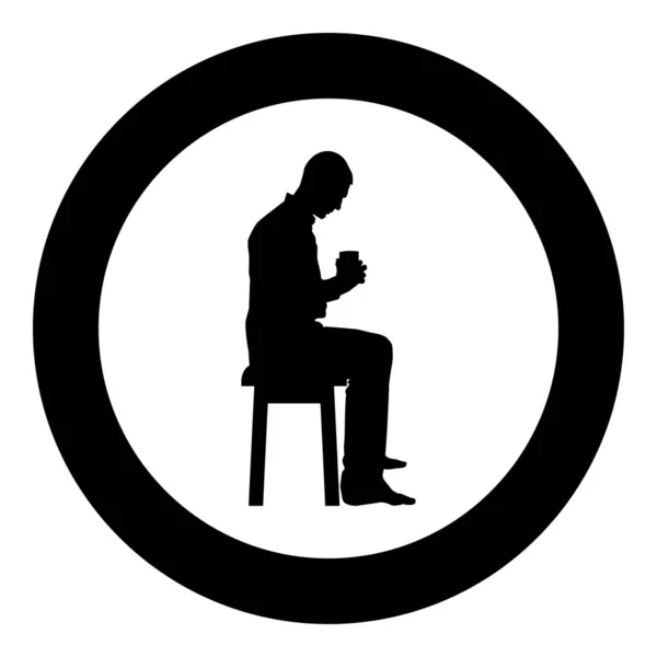 Мужчина держит кружку и глядя на содержимое внутри, сидя на стуле Концепция спокойствия и домашнего комфорта иконка черный вектор цвета в круге круглой иллюстрации плоский стиль изображения — стоковый вектор
