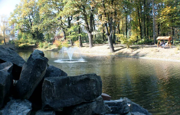 山石块 它看起来不错的背景下 一个小喷泉 秋天的树木和黑暗的水在湖中 创建日历的好照片 — 图库照片