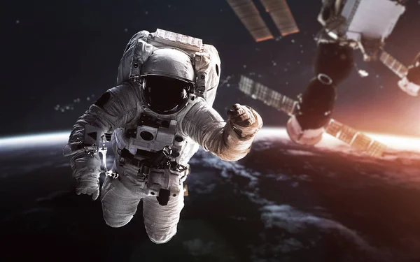 Αστροναύτης στην τροχιά της γης με τον διαστημικό σταθμό πίσω. Elem — Φωτογραφία Αρχείου