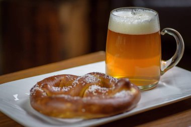 makro closeup bira ve sıcak yumuşak pretzel bir plaka üzerinde bir büyük cam kupa