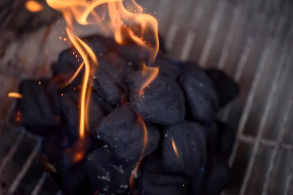 macro closeup of charcoals on grill with flames rising up