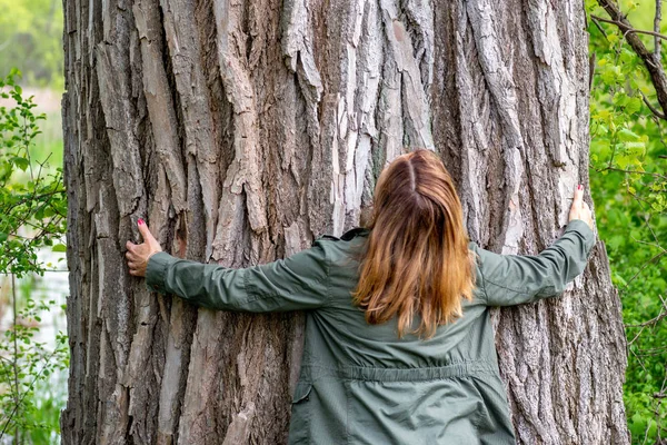 woman hugging an old oak tree in woods