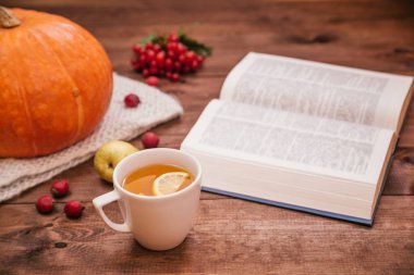 Sonbahar işyeri, kabak, elma ve ahşap masa kitap üstten görünüm.