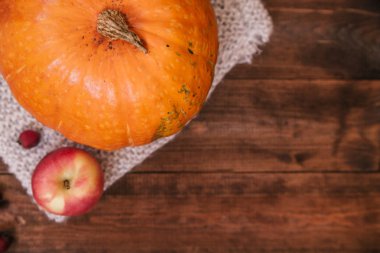 Sonbahar işyeri, kabak, çay, elma ve ahşap masa kitap üstten görünüm.