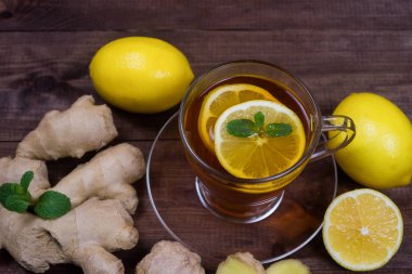Zencefil çayı limon ve nane ahşap bir masa üzerinde. Sağlık kavramı. İçki zengin vitamin soğuk günlerde kış kez.