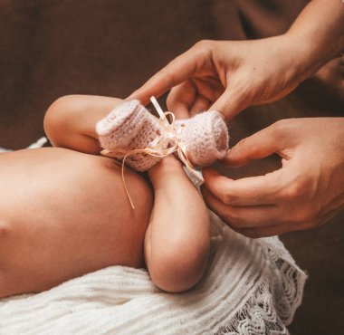 Yenidoğan fotoğrafçılığı, babys bacaklar ve anneler elleri yakın.