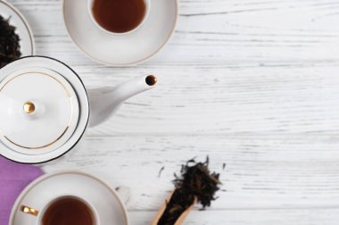 Ahşap beyaz masada Çaydanlık ve bardak. Aromatik siyah çay. Çay töreni kavramı, mola ve dinlenmek. 