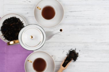 Ahşap beyaz masada Çaydanlık ve bardak. Aromatik siyah çay. Çay töreni kavramı, mola ve dinlenmek. 