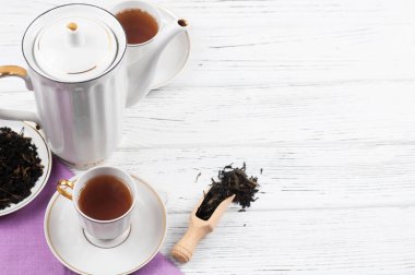 Ahşap beyaz masada Çaydanlık ve bardak. Aromatik siyah çay. Çay töreni kavramı, mola ve dinlenmek. 