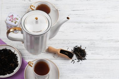 Ahşap beyaz masada Çaydanlık ve bardak. Aromatik siyah çay. Çay töreni kavramı, mola ve dinlenmek. 