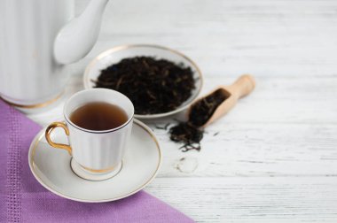 Ahşap beyaz masada Çaydanlık ve bardak. Aromatik siyah çay. Çay töreni kavramı, mola ve dinlenmek. 