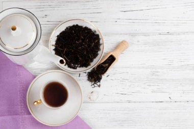 Ahşap beyaz masada Çaydanlık ve bardak. Aromatik siyah çay. Çay töreni kavramı, mola ve dinlenmek. 