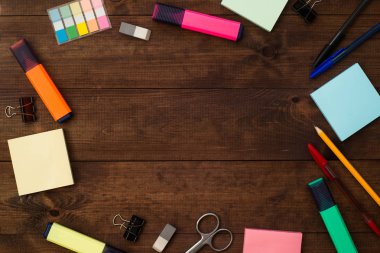 Okula geri dönelim. Kahverengi ahşap masaüzerinde okul malzemeleri. Metin için yer.