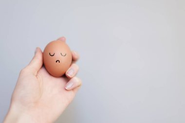 Üzgün suratlı yumurta tutan kadın. 