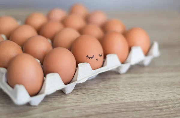 Egg with happy face in the basket with other eggs.