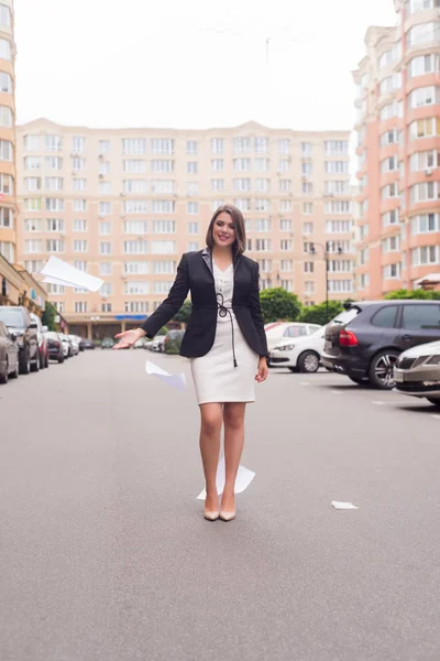 Beautiful  business woman in suit with folder of documents in her hands outdoors.