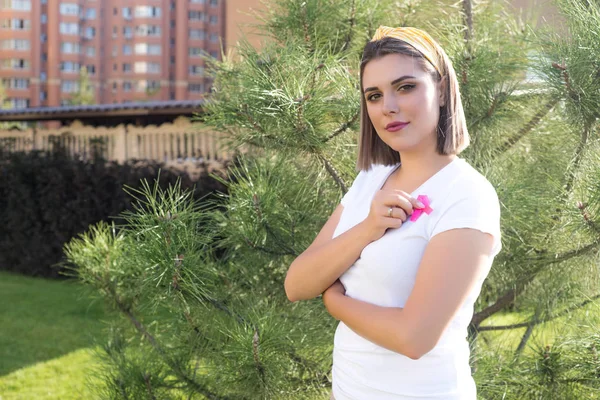 La ragazza con in mano un nastro rosa, simbolo del cancro. Cancro al seno — Foto Stock