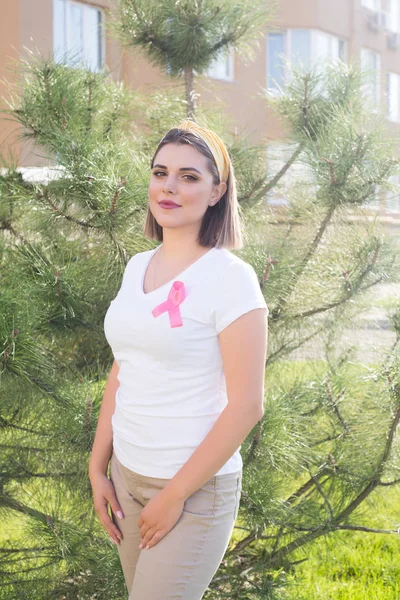 La ragazza con in mano un nastro rosa, simbolo del cancro. Cancro al seno — Foto Stock