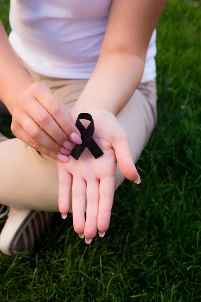 La chica sosteniendo una cinta negra, símbolo de cáncer . — Foto de Stock