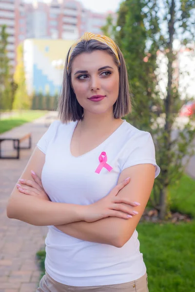 年轻女孩的肖像与粉红色丝带，癌症的象征. — 图库照片