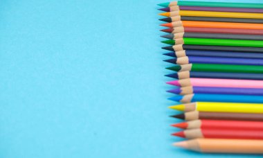 Pembe arkaplanda renkli kalemler, metin için yer