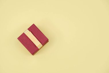 Sarı arka planda fiyonklu hediye kutusu..