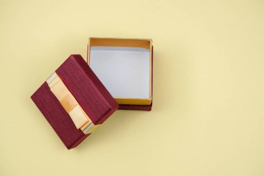 Sarı arka planda fiyonklu hediye kutusu..