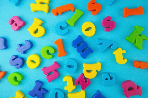 Plastic colourful alphabet letters on the blue background.