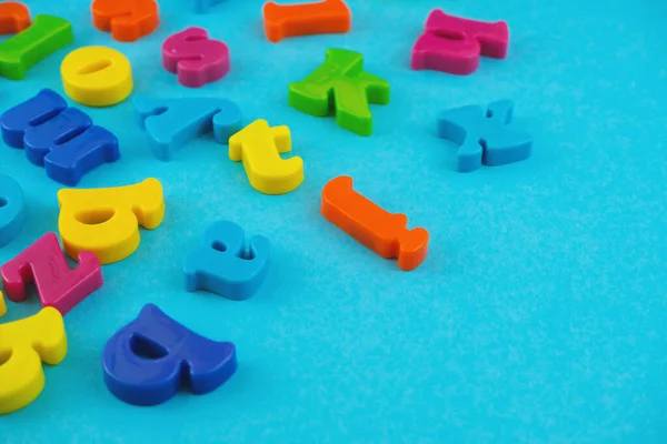 Plastic colourful alphabet letters on the blue background.