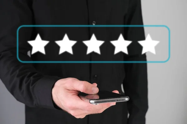 Man giving rating, leaving review with a happy face emotion icon. Product quality survey. Feedback concept.