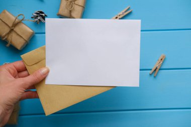 Mavi ahşap desenli masaya beyaz bir tebrik kartı koyun. Bir metin için yer.